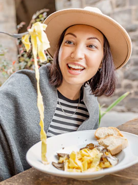 Woman enjoying pasta during a cooking class in Rome.