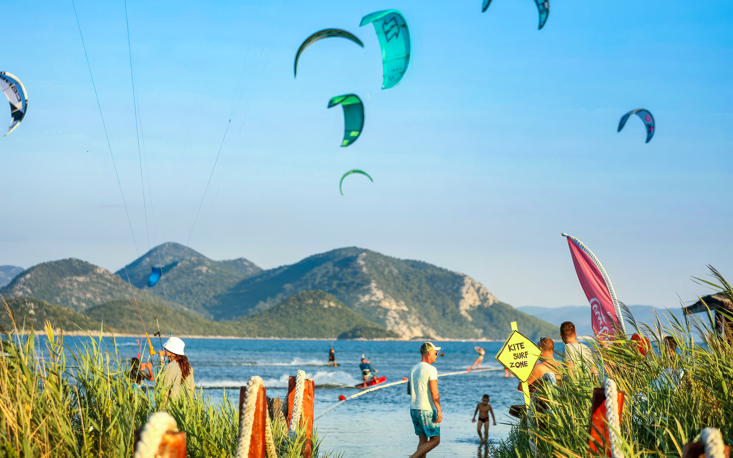 Kiteboarders at Delta Neretva, Croatia with mountains in the background.