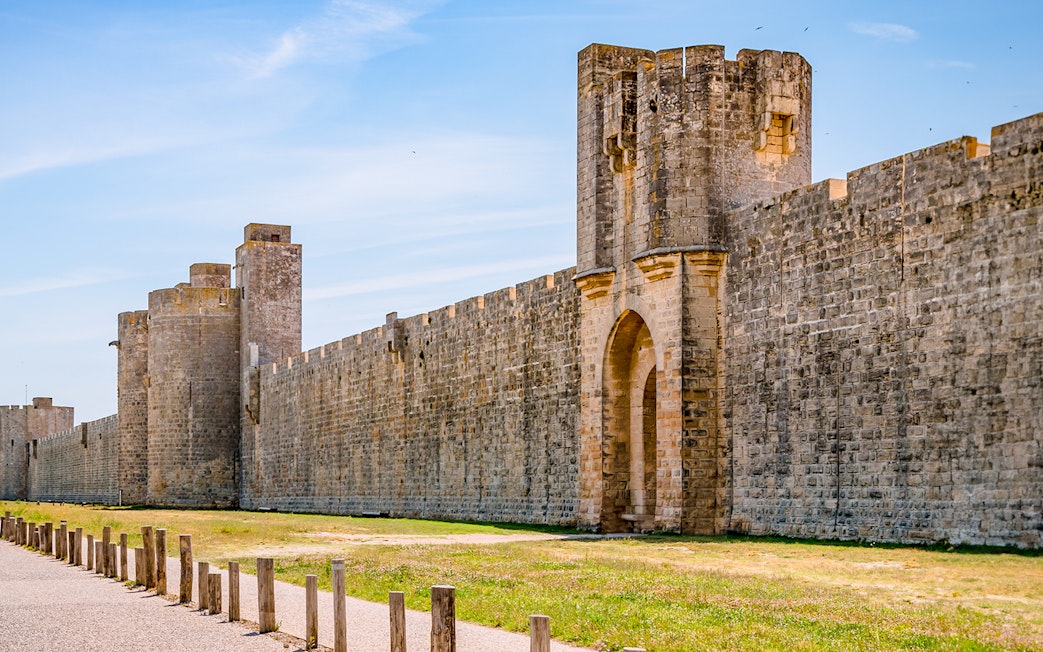 Towers and ramparts of Aigues-Mortes under a clear blue sky.