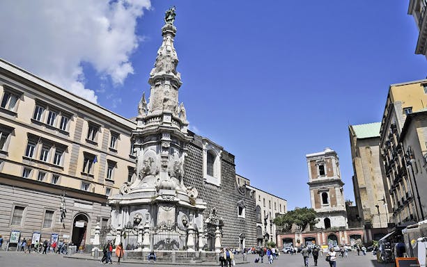 Piazza del Gesù Nuovo in Naples with tourists exploring the square.
