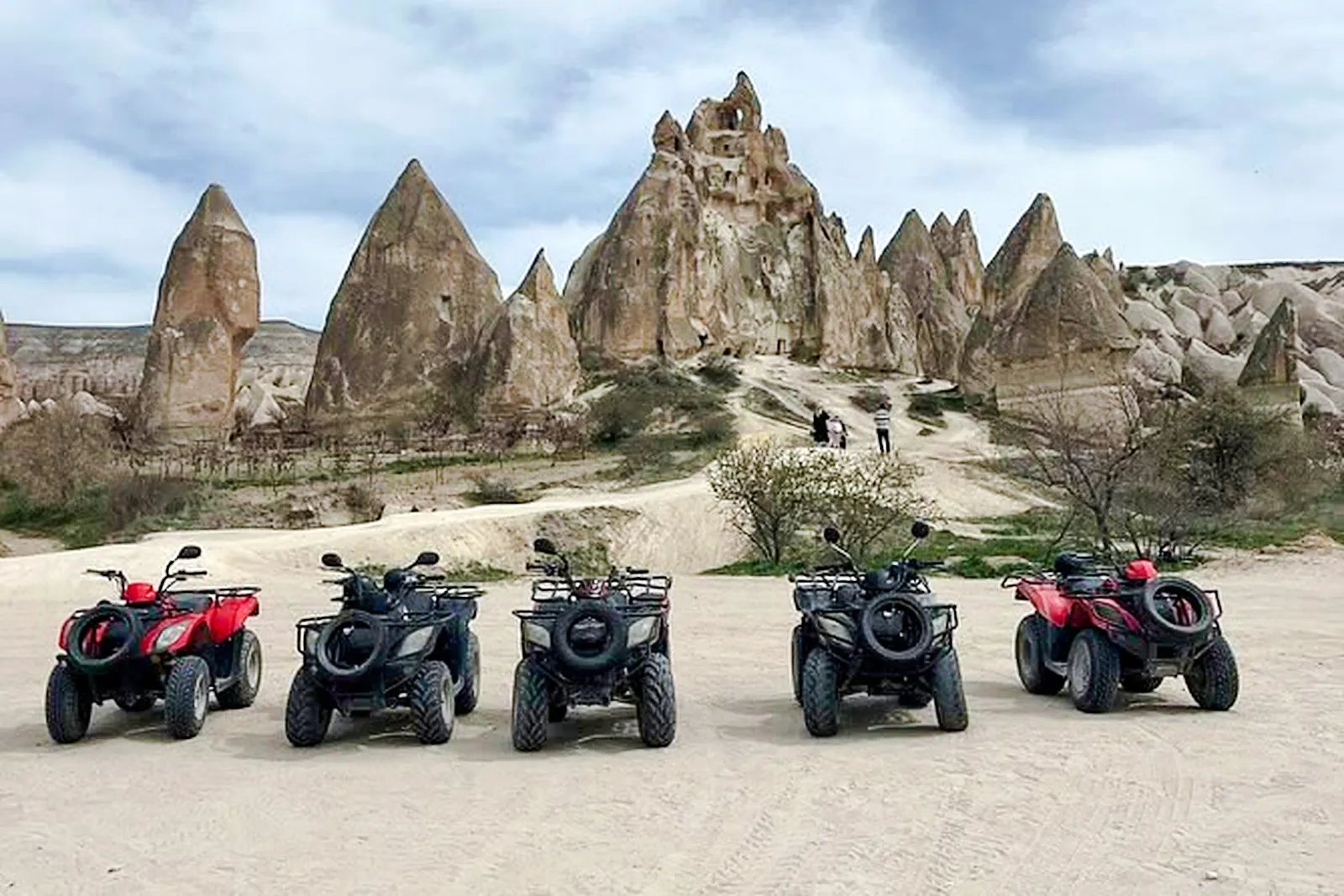 ATVs parked in front of Cappadocia rock formations, Turkey, ready for a tour.