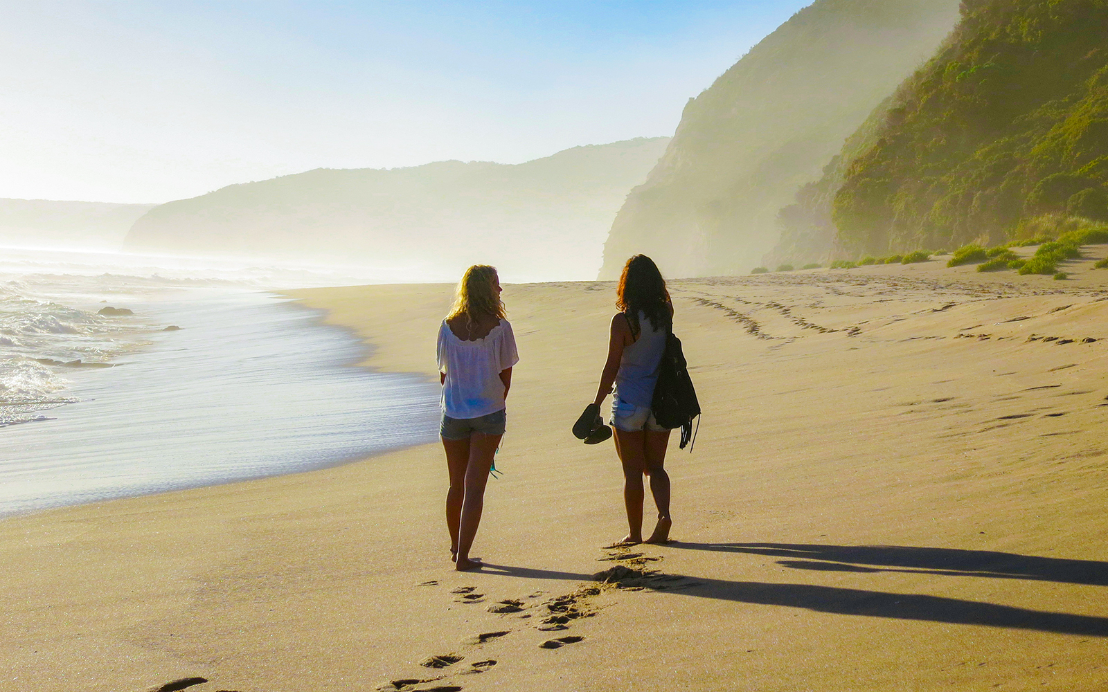 Women walking along Johanna Beach shoreline in Australia