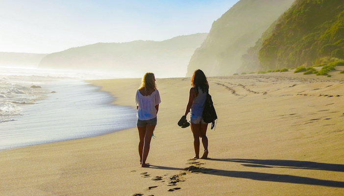 Women walking along Johanna Beach shoreline in Australia