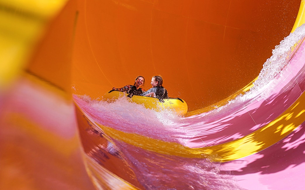 Two girls on a water tube sliding down the Python waterslide at Waterbom Bali.