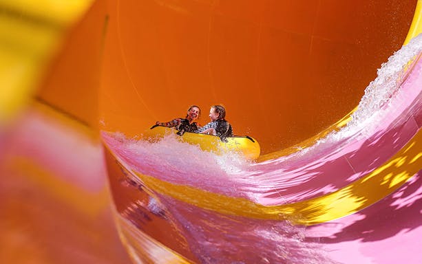 Two girls on a water tube sliding down the Python waterslide at Waterbom Bali.