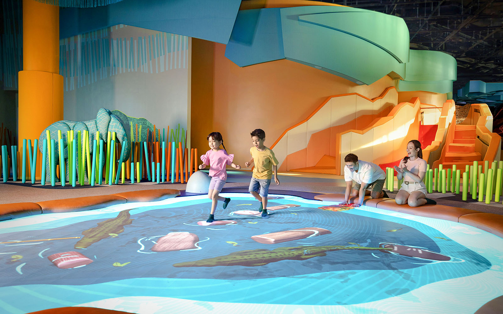 Children playing on interactive water-themed floor at Curiosity Cove Grassland Water Hole.