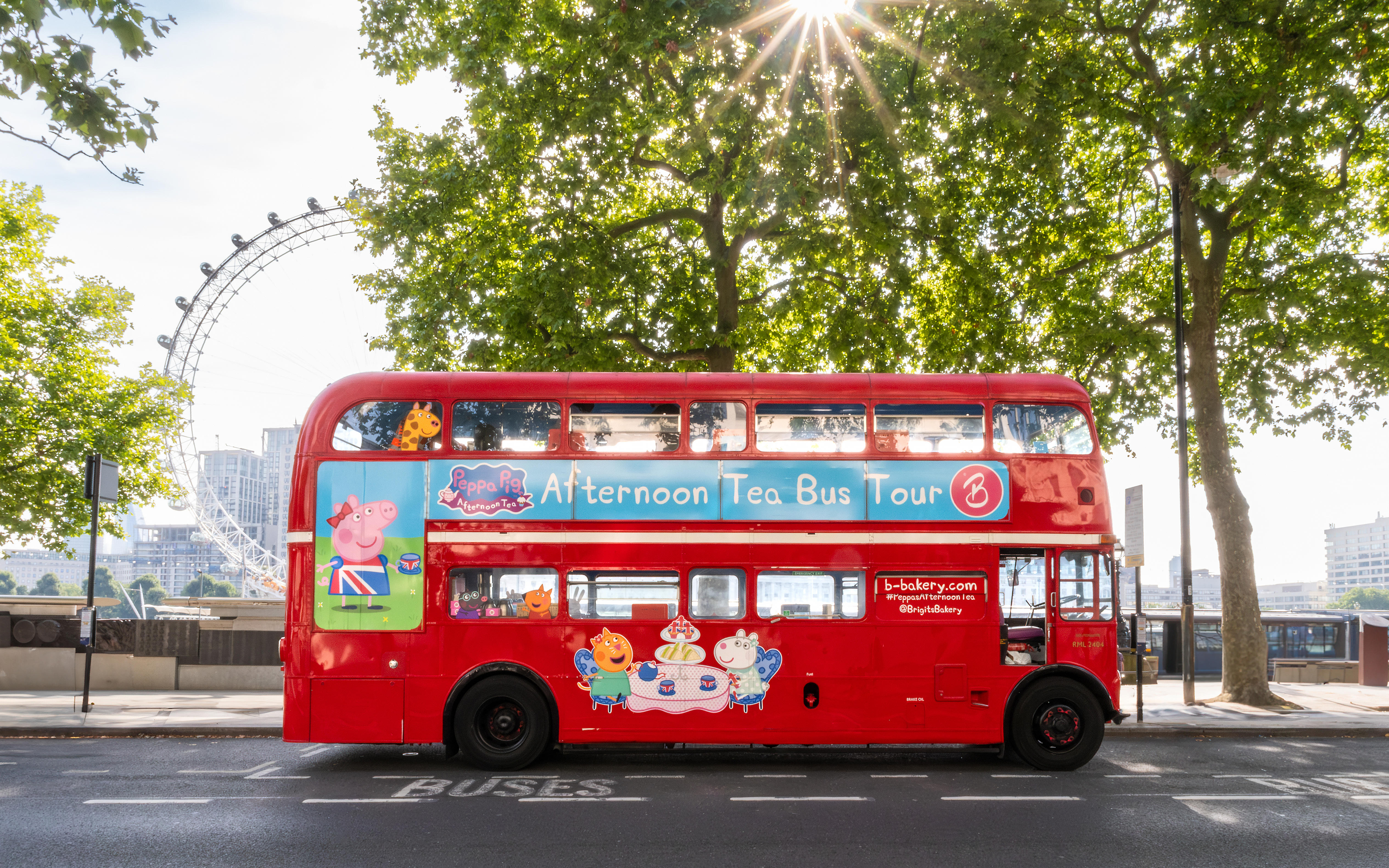 Red double-decker bus for Brigit’s Afternoon Tea Tour in London with London Eye in background.