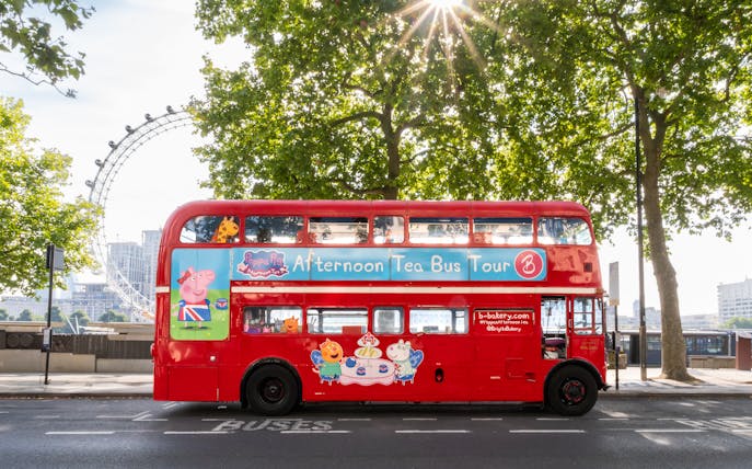 Red double-decker bus for Brigit’s Afternoon Tea Tour in London with London Eye in background.