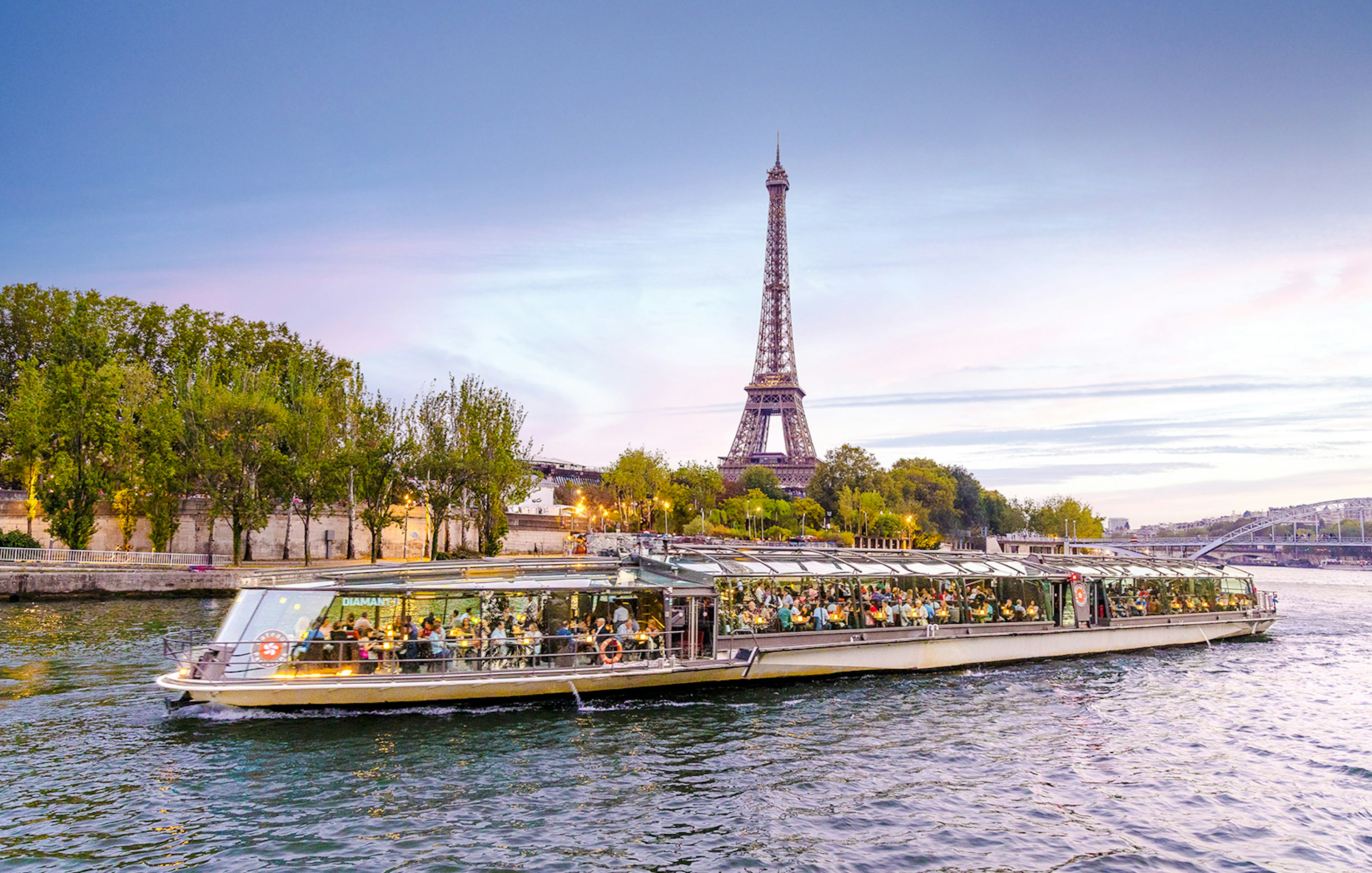 Seine River cruise boat with Eiffel Tower in the background, Paris.