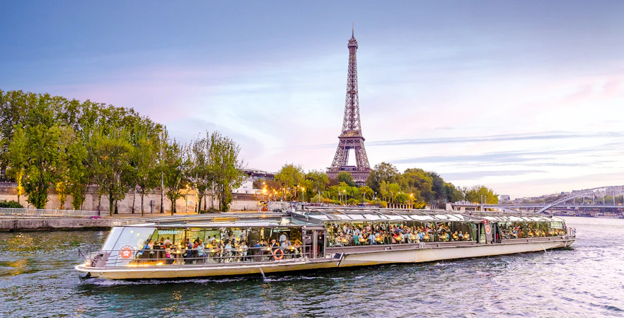 Seine River cruise boat with Eiffel Tower in the background, Paris.