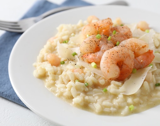 Seafood risotto dish with shrimp and mussels served at a coastal restaurant in Italy.