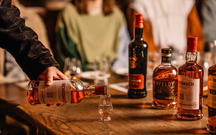 Pouring whisky into a glass during an underground whisky tour in Edinburgh.