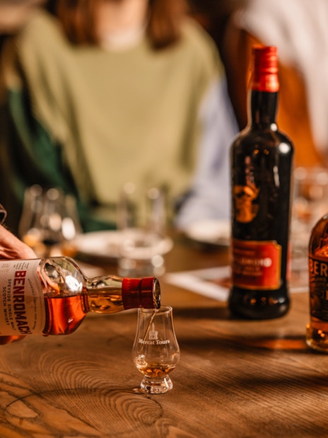 Pouring whisky into a glass during an underground whisky tour in Edinburgh.