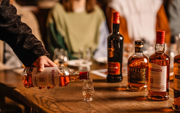 Pouring whisky into a glass during an underground whisky tour in Edinburgh.