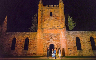 Group on Port Arthur Historic Site Ghost Tour at night, standing by historic ruins.