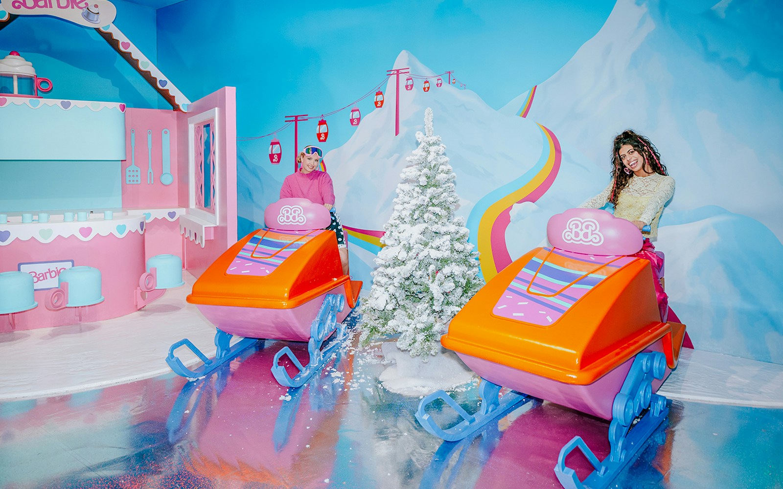 Barbie-themed ski ride with colorful sleds and snowy mountain backdrop.