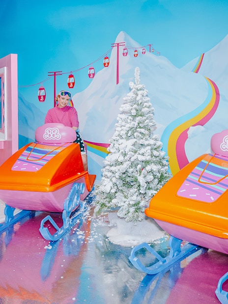 Barbie-themed ski ride with colorful sleds and snowy mountain backdrop.