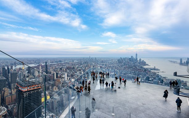 Visitors on the Edge sky deck in New York with views of Central Park and the city skyline.