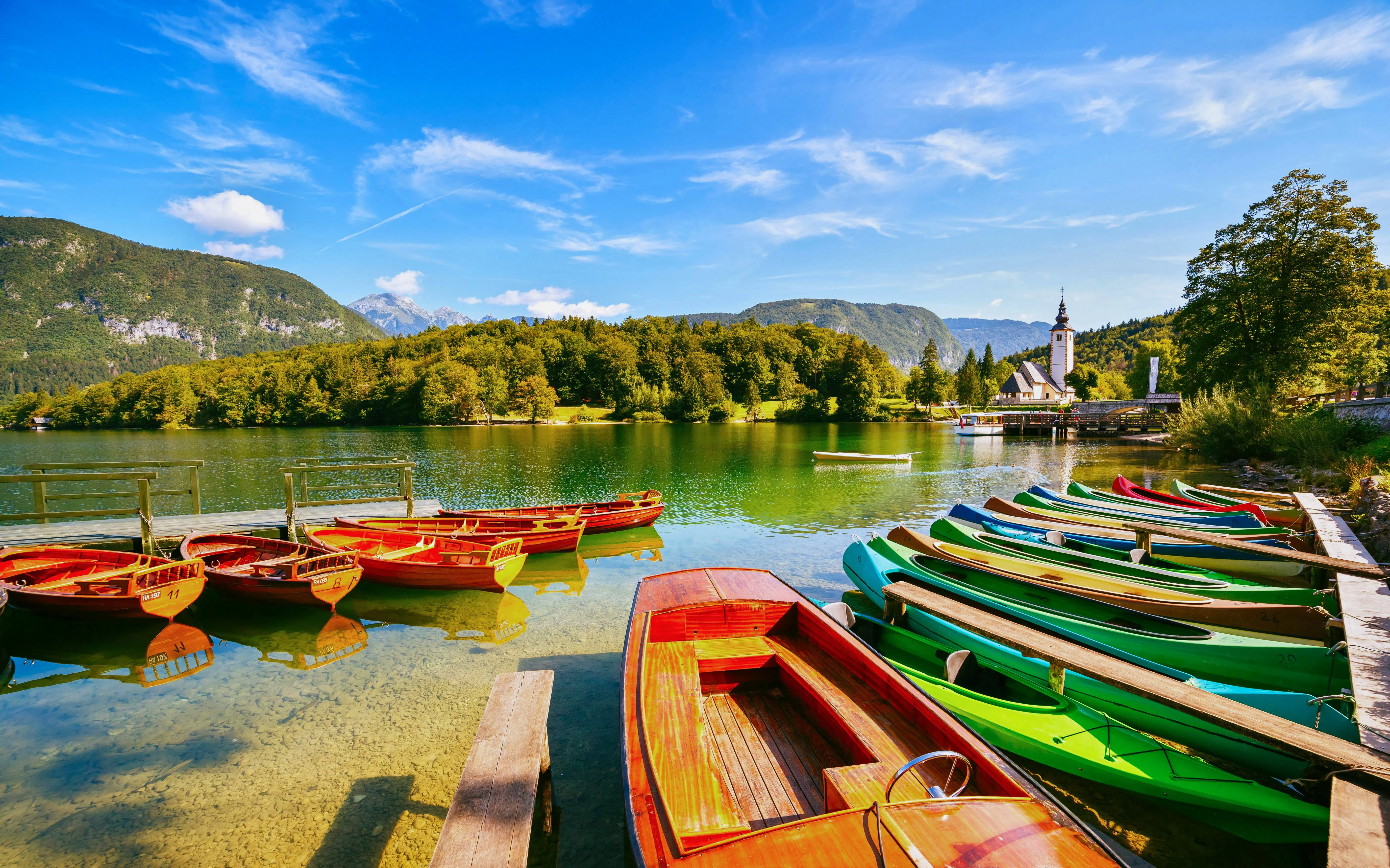 Moored colorful canoes and wooden boats on Bohinj Lake, Triglav National Park, Slovenia.