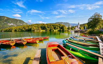 Moored colorful canoes and wooden boats on Bohinj Lake, Triglav National Park, Slovenia.
