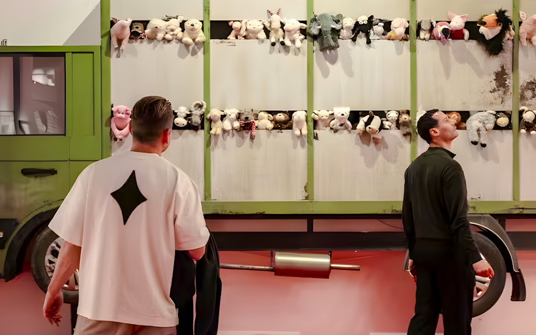 Visitors observing stuffed animals on a truck at Banksy Limitless Exhibition.