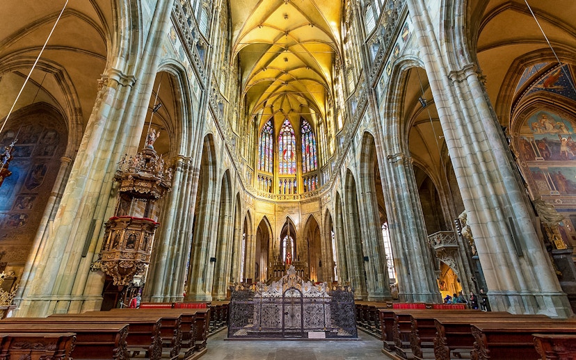 Interior of St. Vitus Cathedral at Prague Castle with stained glass windows.