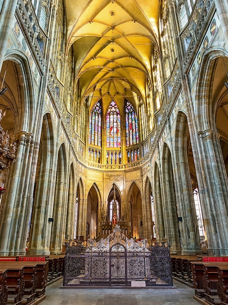 Interior of St. Vitus Cathedral at Prague Castle with stained glass windows.