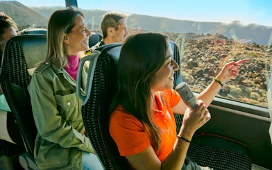 Guests enjoying a guided coach tour on Mount Teide with scenic views outside the window.