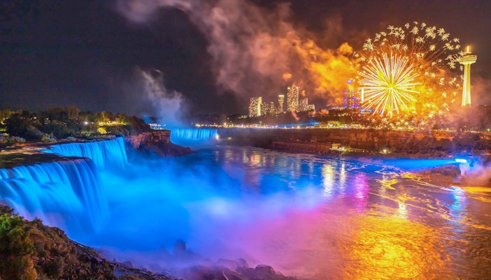Niagara Falls Summer Solstice Event with illuminated vibrant lights reflecting on the cascading water.