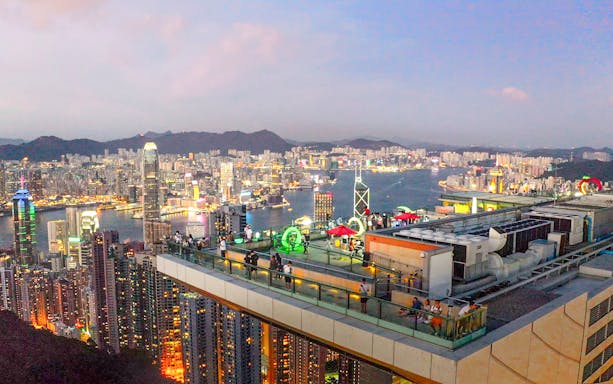 Sky Terrace 428 view of Hong Kong skyline at dusk with visitors on observation deck.