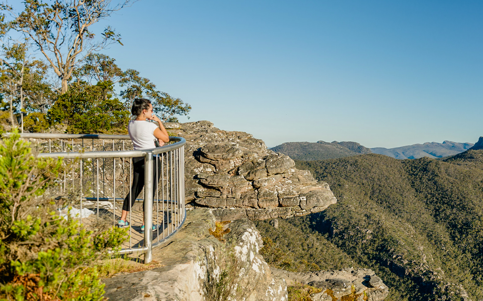 Visitor at Grampians lookout, viewing expansive wilderness on a guided tour from Melbourne.