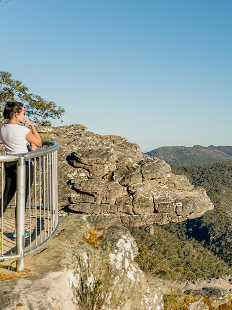 Visitor at Grampians lookout, viewing expansive wilderness on a guided tour from Melbourne.