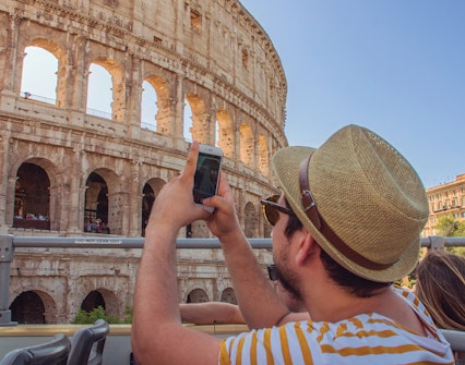 Tourists on Big Bus Tours Rome taking photos of the Colosseum.