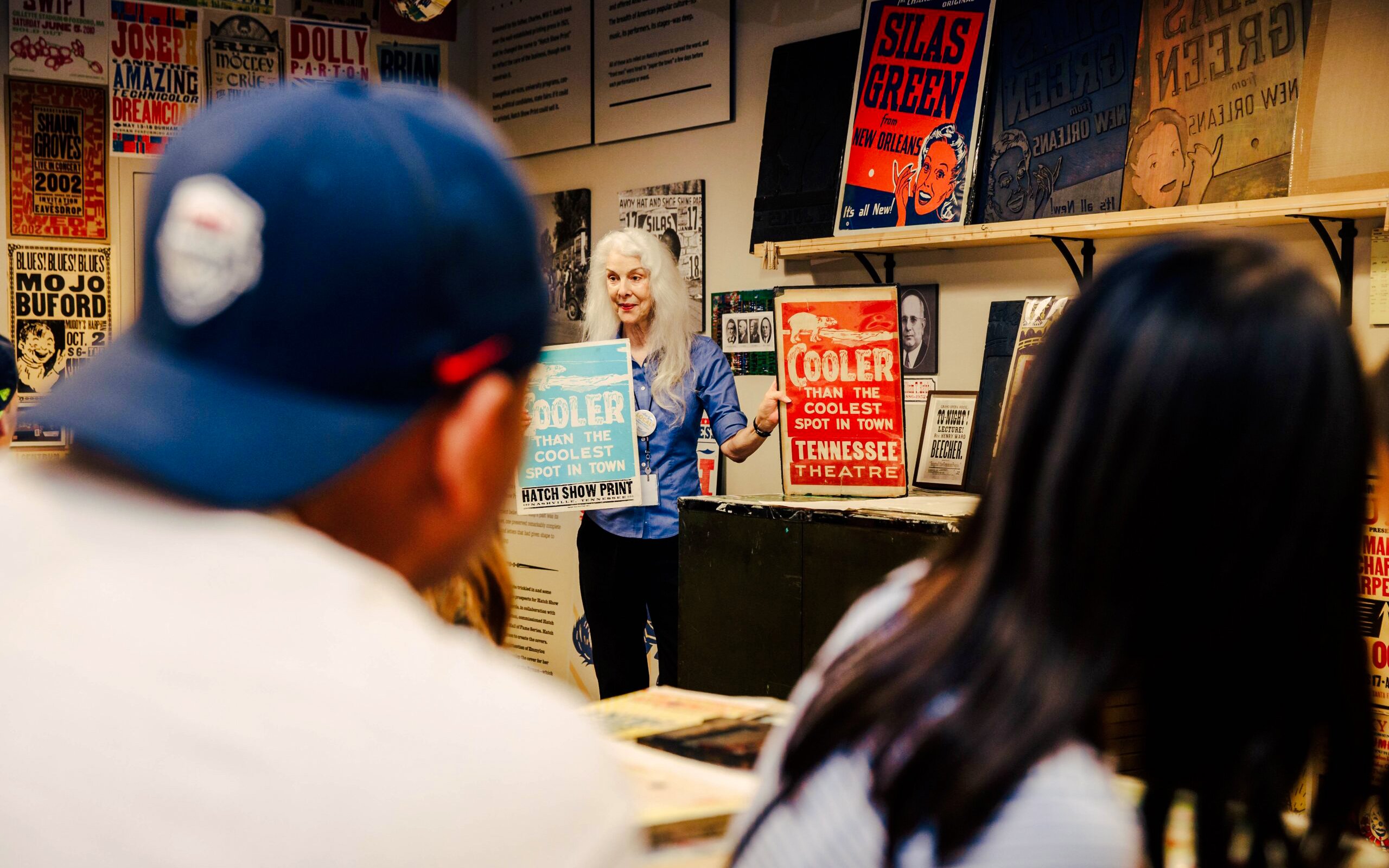 Hatch Show Print tour guide displaying vintage posters in Nashville print shop.