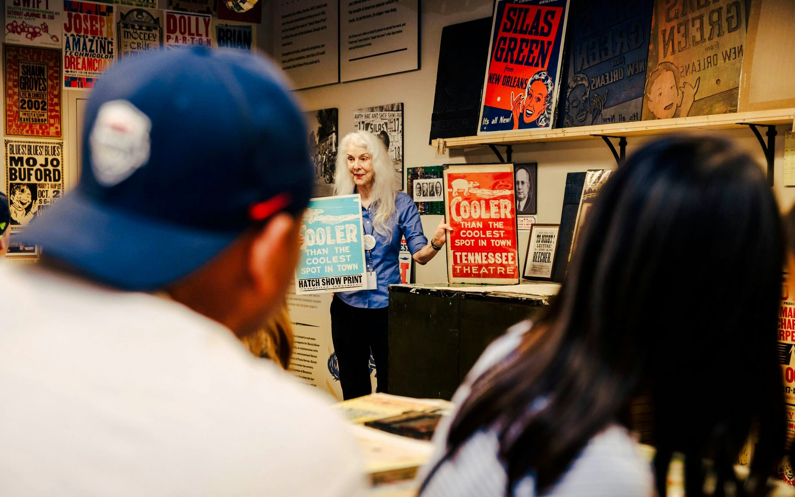 Hatch Show Print tour guide displaying vintage posters in Nashville print shop.