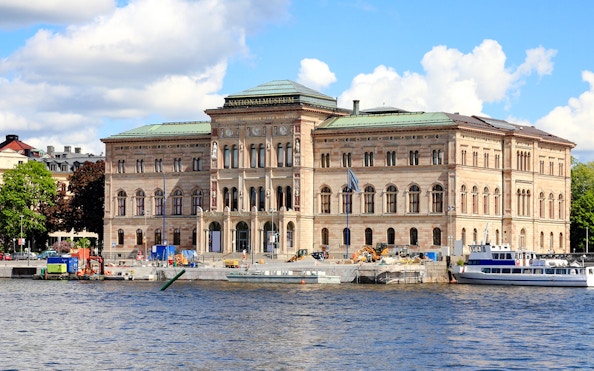 Stockholm National Museum by the waterfront with boats in view.
