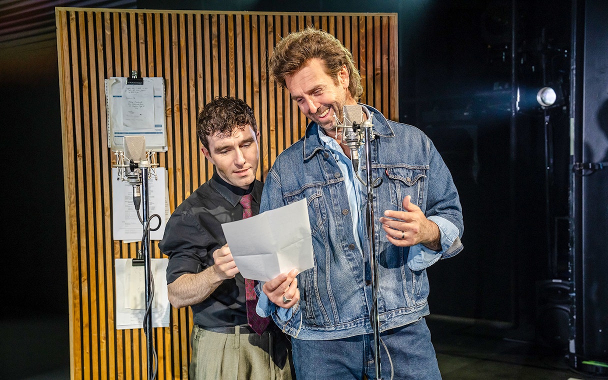 Two performers reading a script at Just for One Day event.