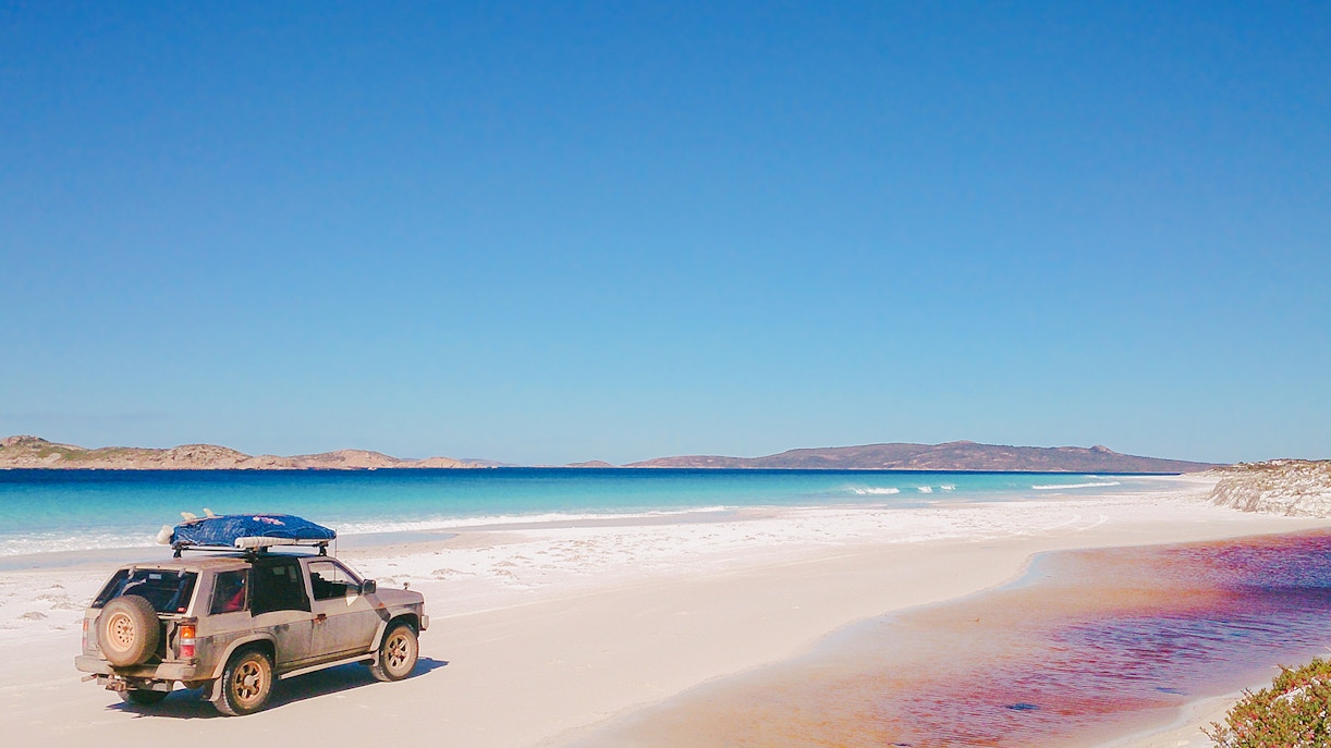 4WD vehicle on a sandy beach with ocean view, part of Noosa kayak and beach adventure tour.
