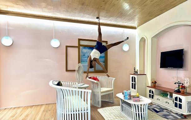 Person posing upside down in a living room at Upside Down World Bali.