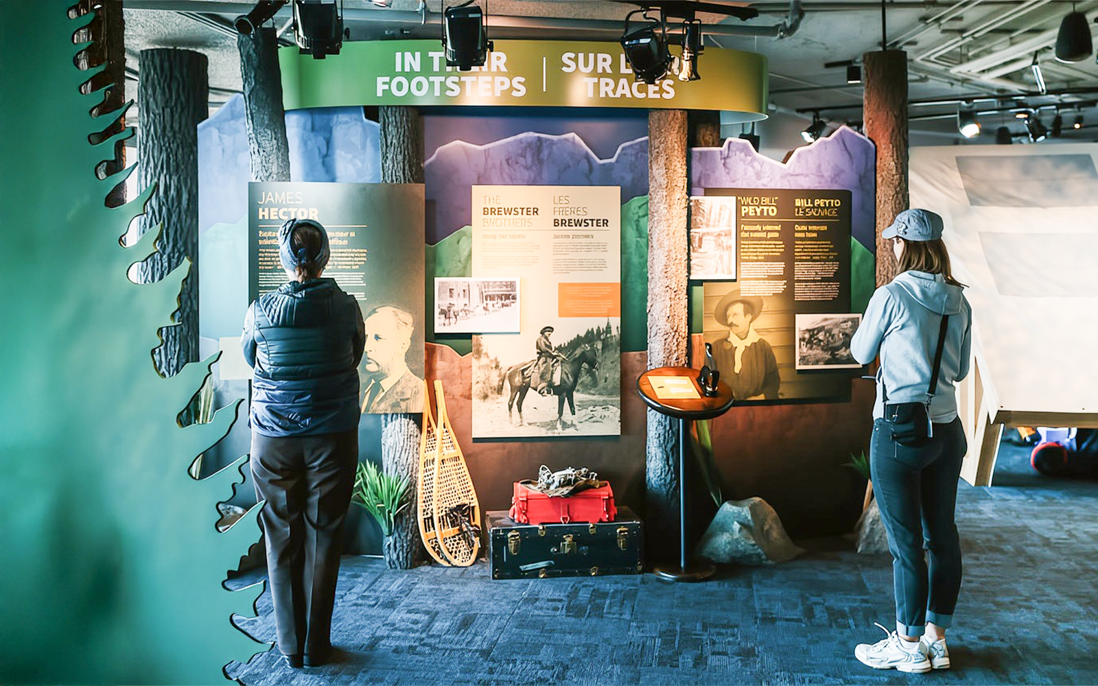 Guests reading information boards about Banff Gondola history and explorers.