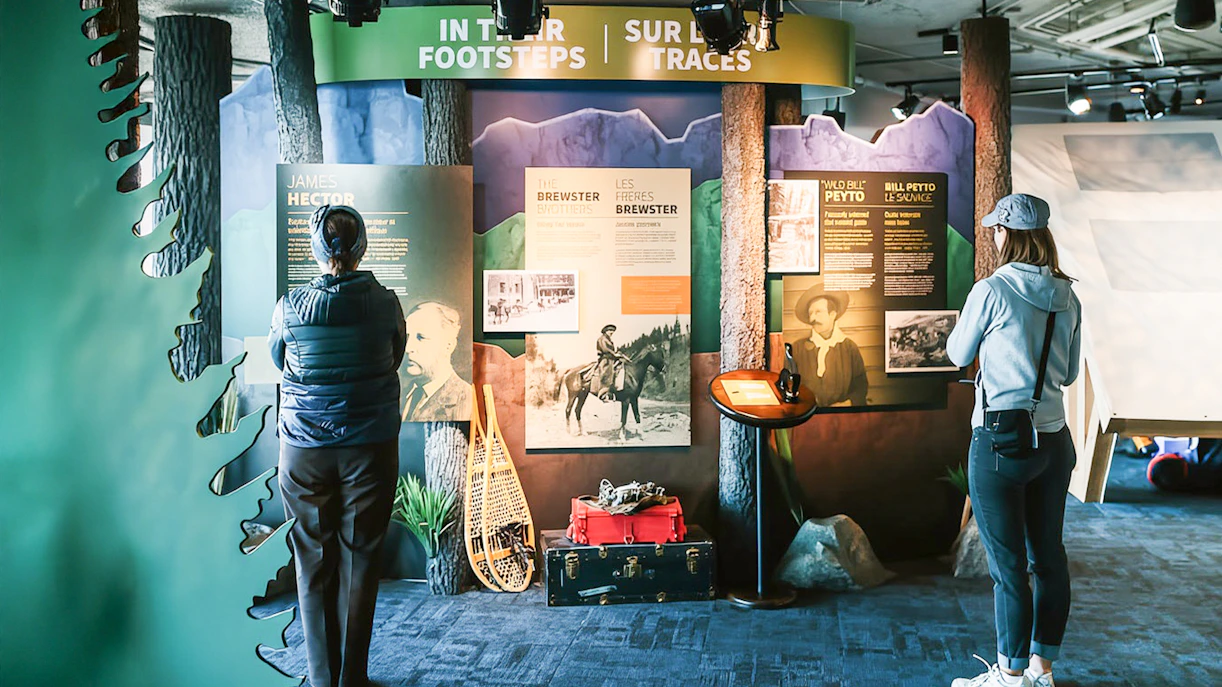 Guests reading information boards about Banff Gondola history and explorers.