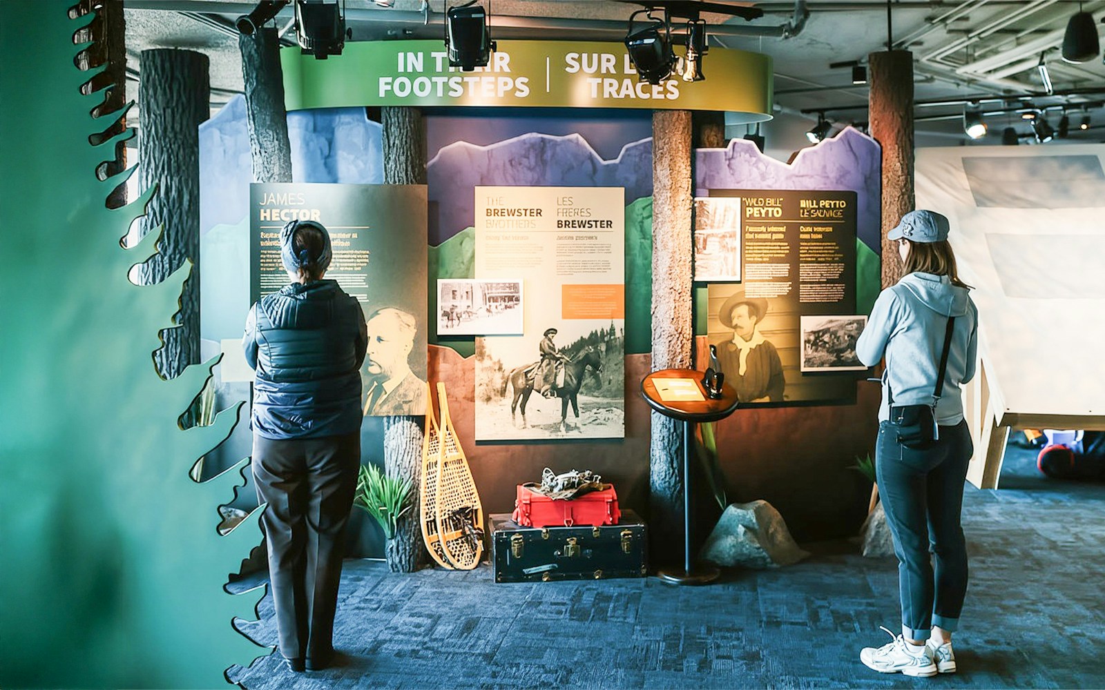 Guests reading information boards about Banff Gondola history and explorers.