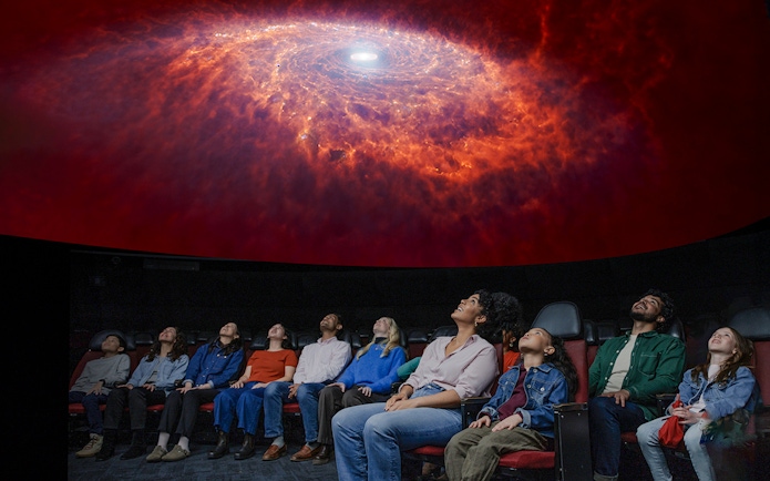 Visitors watching a cosmic display at the Encounters in the Milky Way exhibit, American Museum of Natural History.