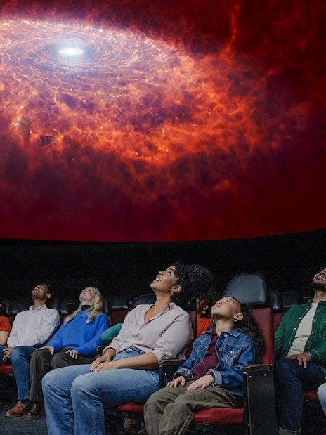 Visitors watching a cosmic display at the Encounters in the Milky Way exhibit, American Museum of Natural History.