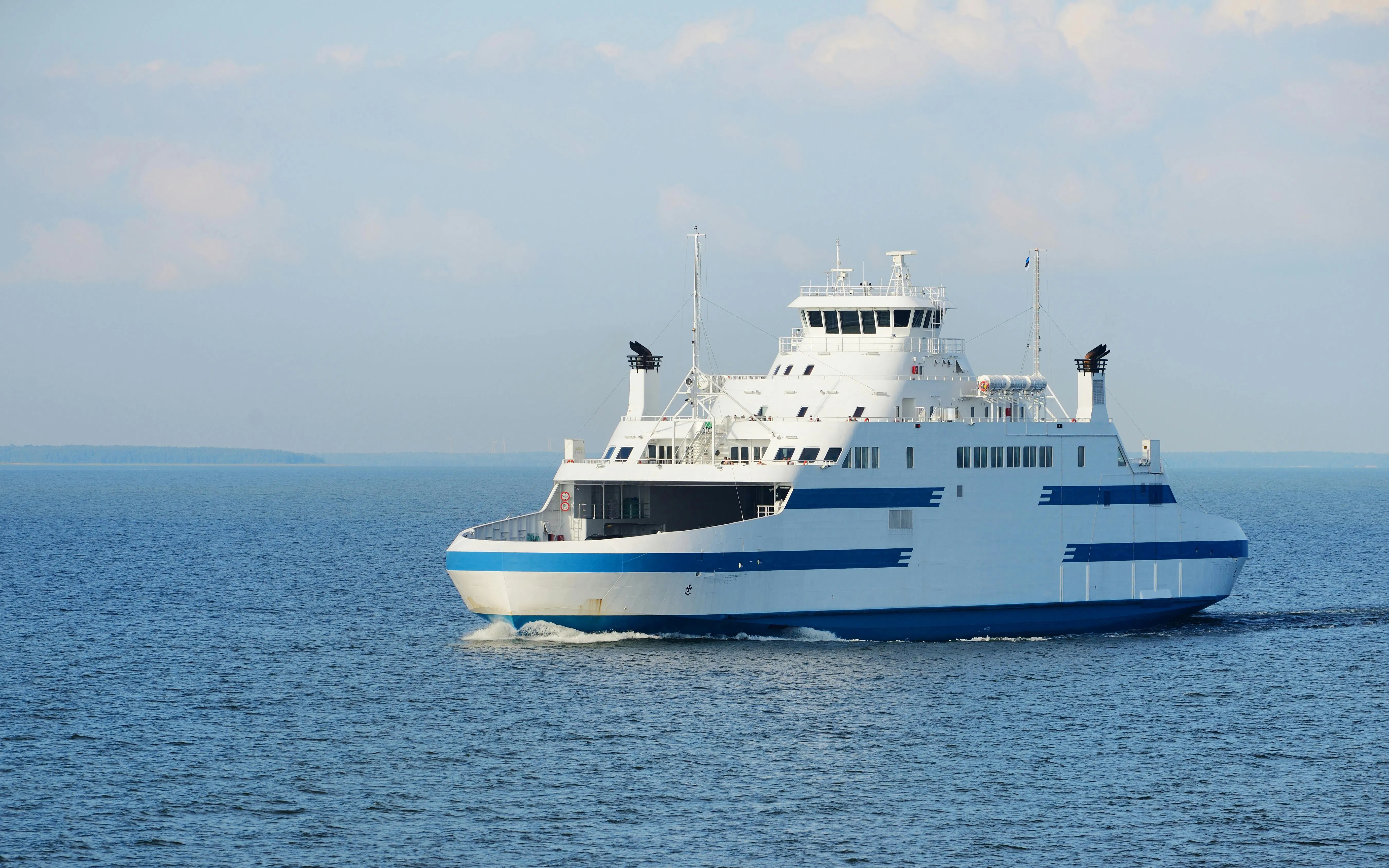 Ferry sailing on a sunny day across calm blue waters.