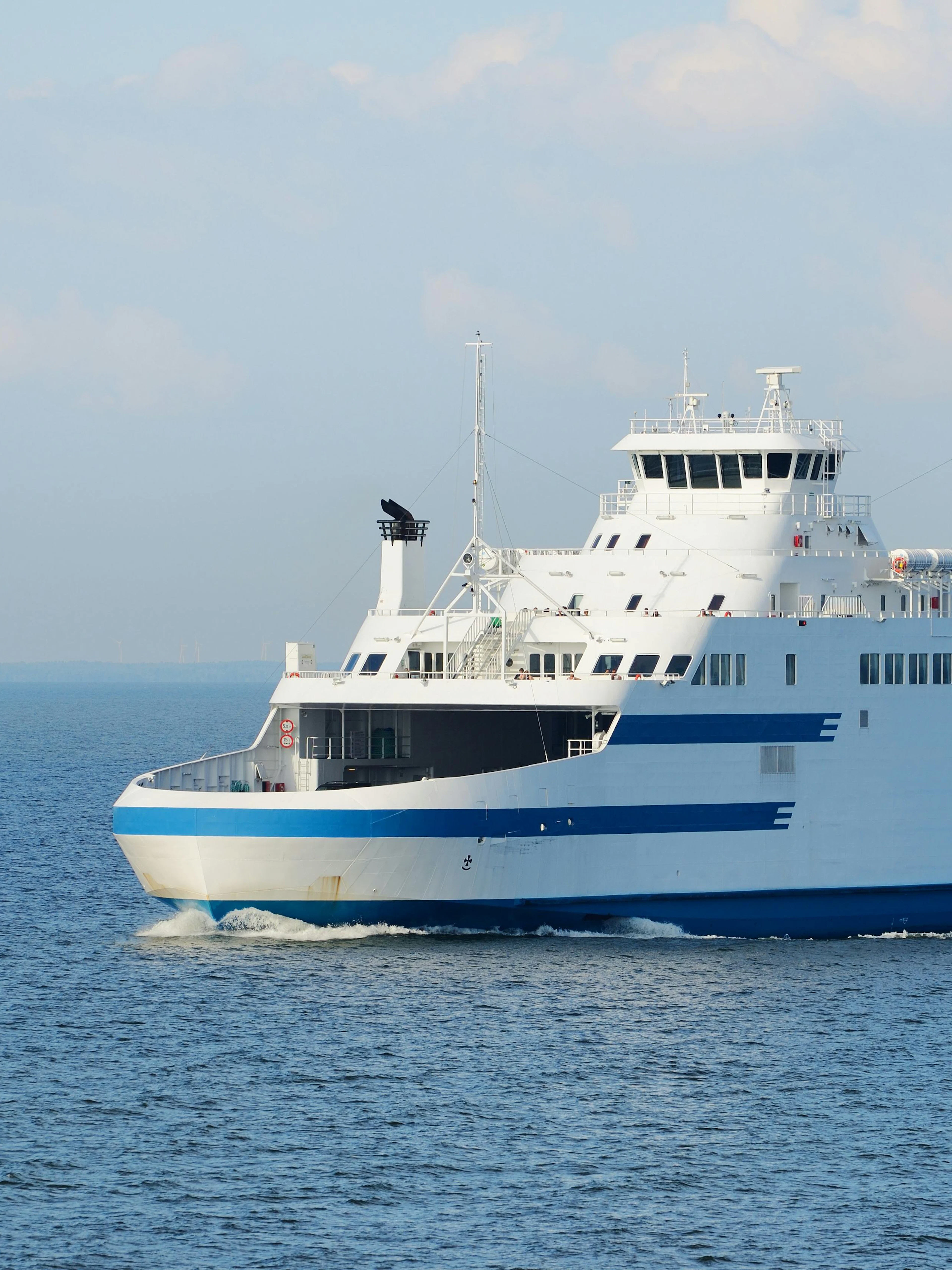 Ferry sailing on a sunny day across calm blue waters.