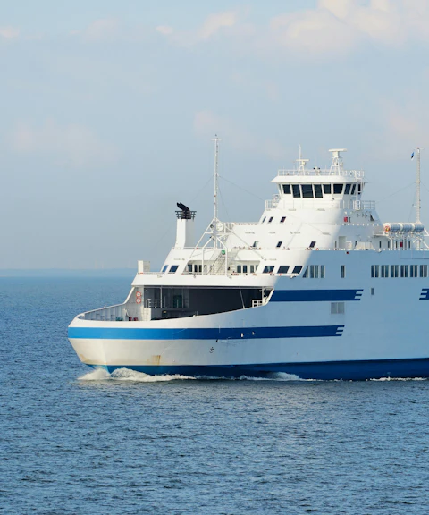 Ferry sailing on a sunny day across calm blue waters.