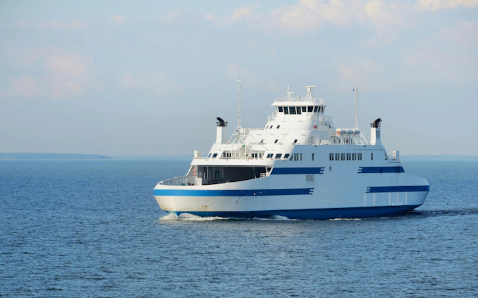 Ferry sailing on a sunny day across calm blue waters.