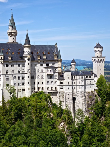 Neuschwanstein Castle surrounded by lush greenery, viewed on a day trip from Munich.
