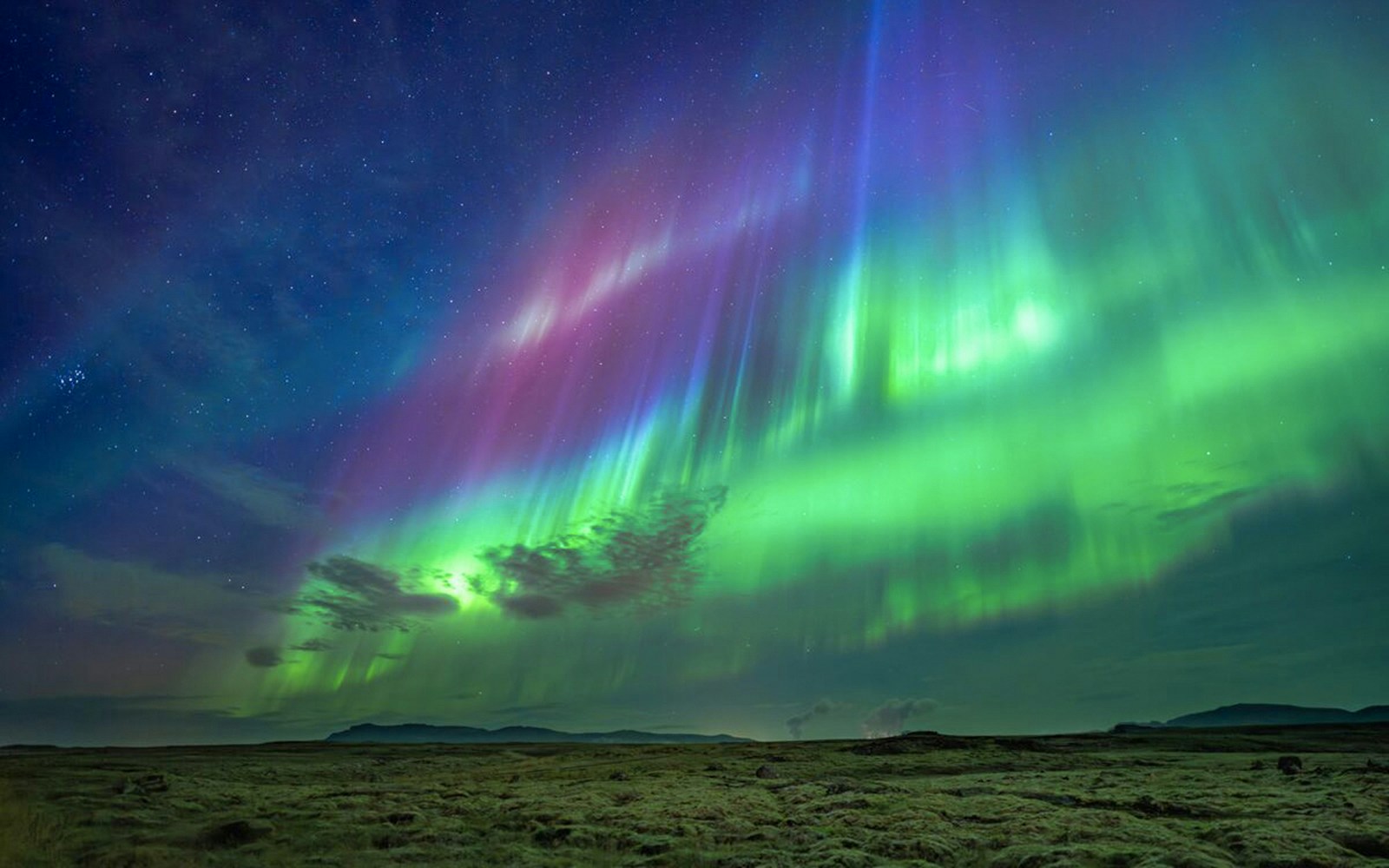 Northern lights over landscape during Premium Northern Lights Super Jeep Tour.